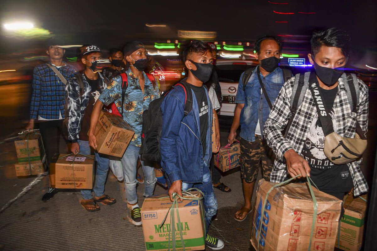 Calon pemudik yang terjaring razia penyekatan berjalan menaiki bus yang akan membawa mereka ke Terminal Pulogebang, Jakarta.