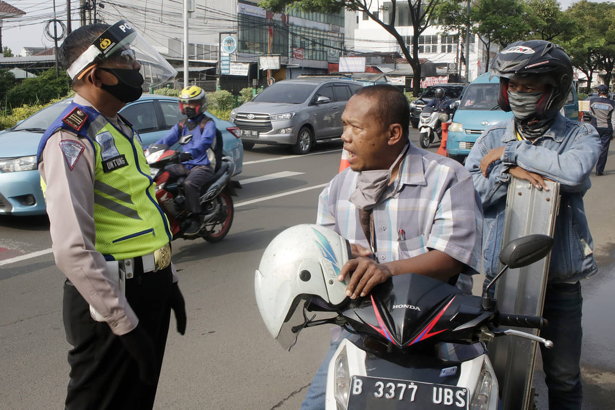 Polisi memberikan imbauan dan teguran kepada pengendara yang tidak memakai masker saat PSBB