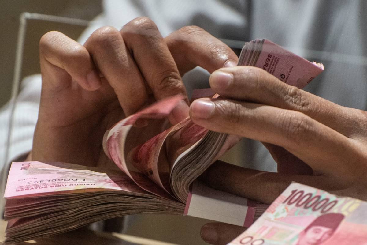 Karyawan menghitung uang rupiah di Jakarta.