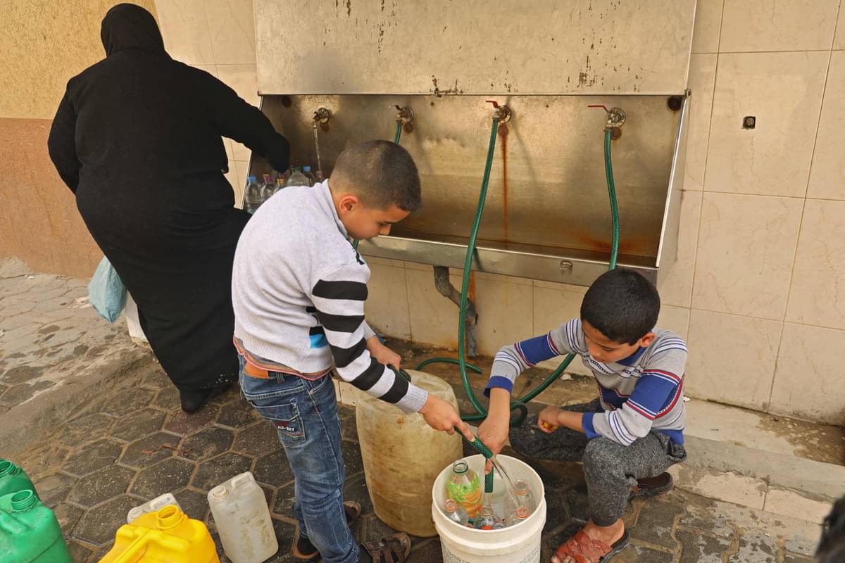 Anak laki-laki Palestina mengisi botol dengan air dari keran umum di Kota Gaza, Senin (22/3).