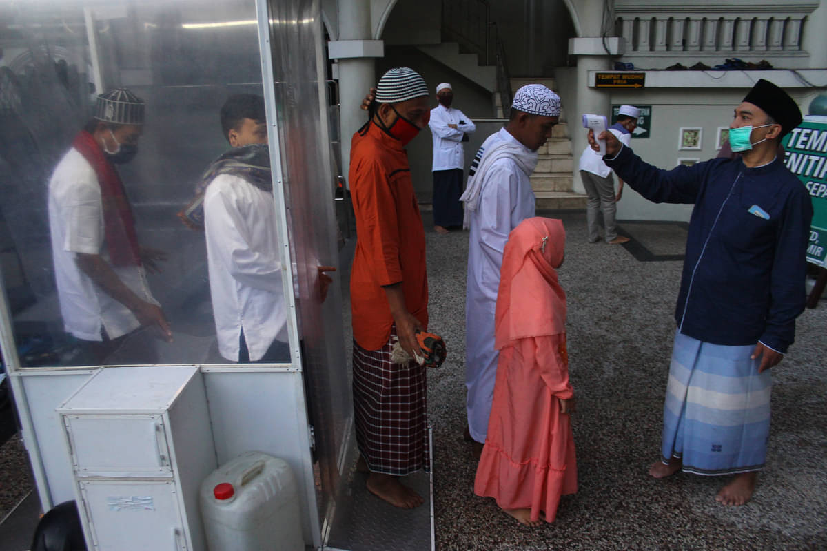 Takmir masjid mengukur suhu tubuh para jemaah sebelum mengikuti shalat Id saat Hari Raya Idul Fitri 1 Syawal 1441 H di Masjid Agung Jamik, M