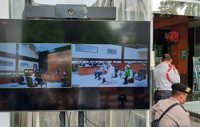 Layar menampilkan suasana sidang lanjutan Rizieq untuk perkara tes usap RS UMMI Bogor di Pengadilan Negeri Jakarta Timur, Kamis (17/6).