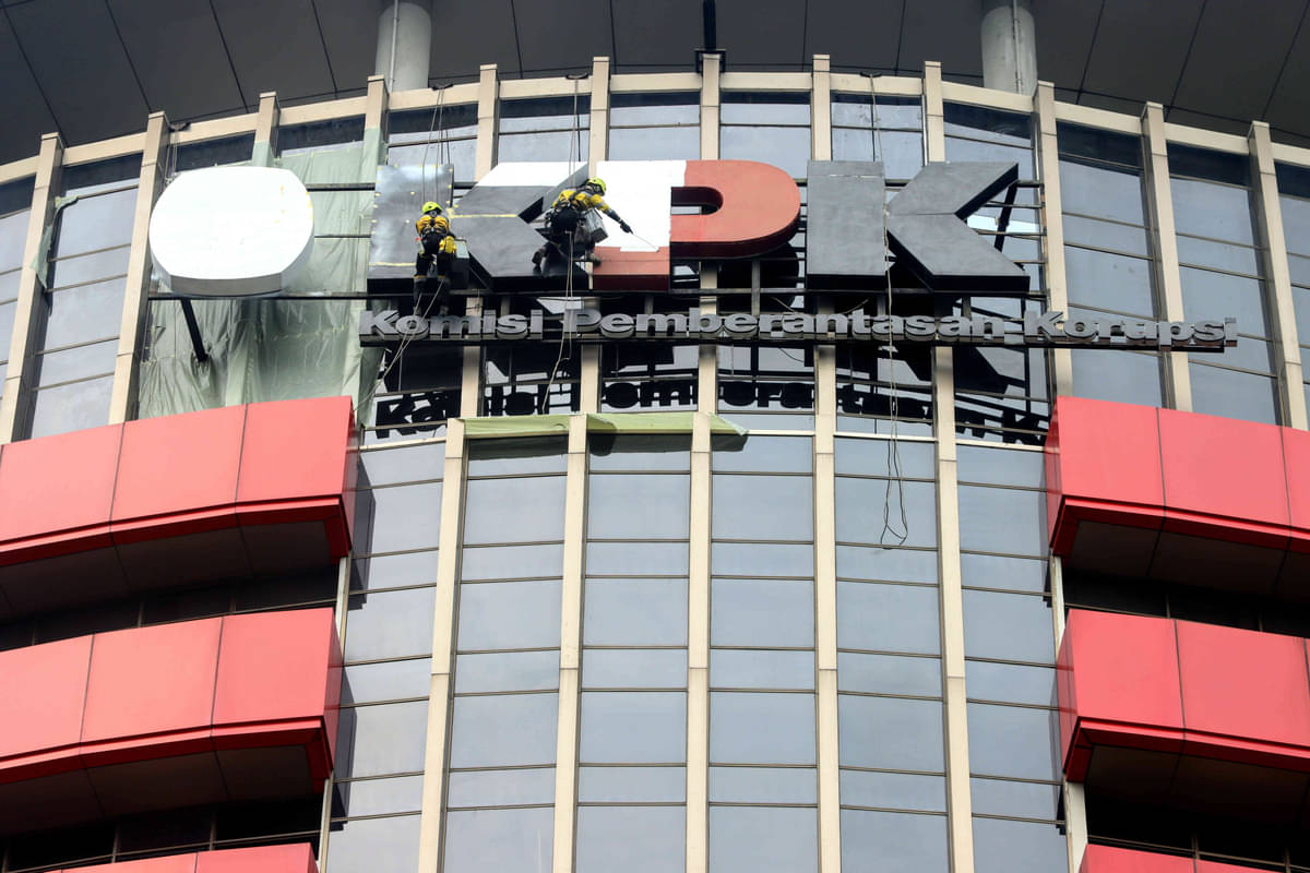 Pekerja mengecat logo KPK yang terpasang di gedung Merah Putih, Jakarta.