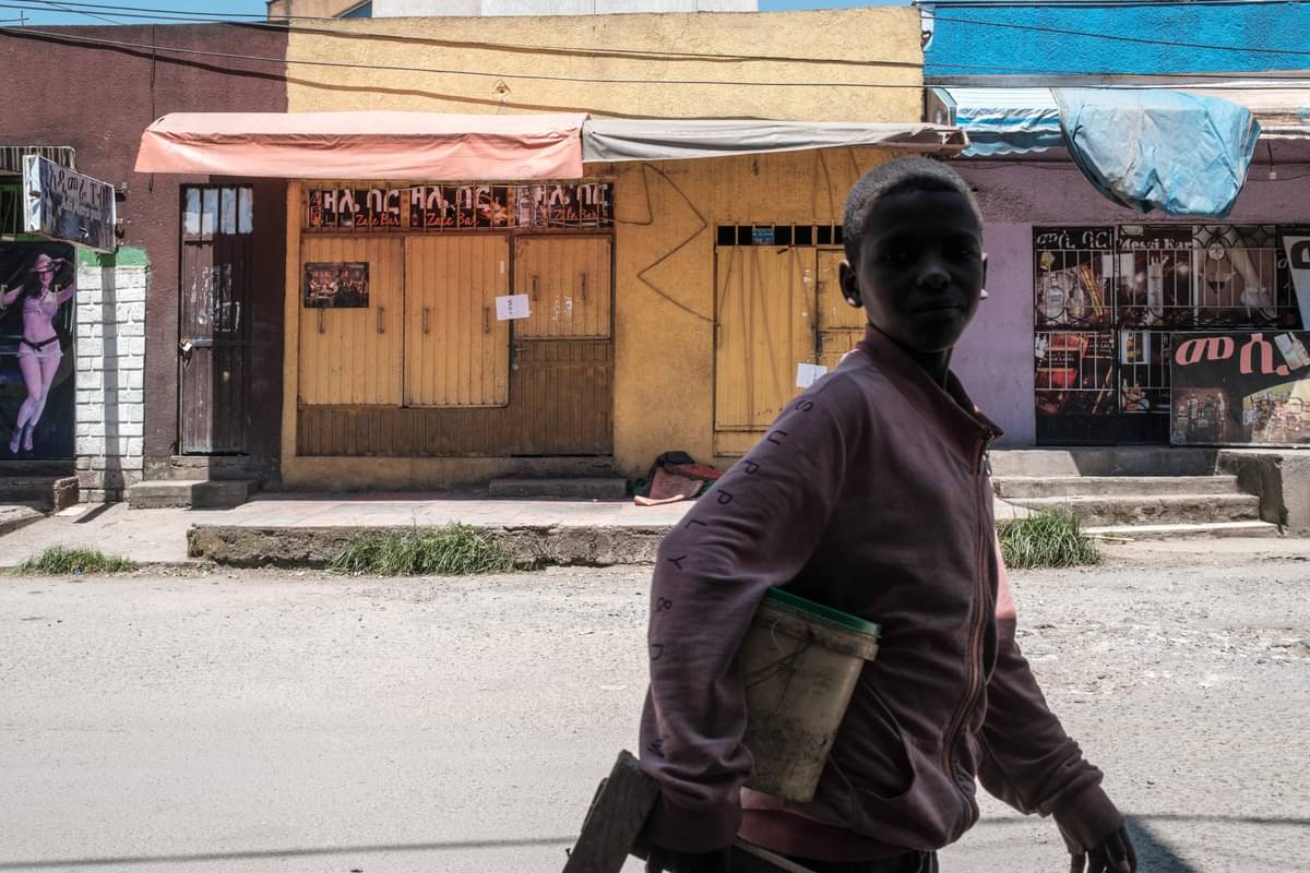 Seorang remaja berjalan di depan toko yang tutup di Addis Ababa, Ethiopia.