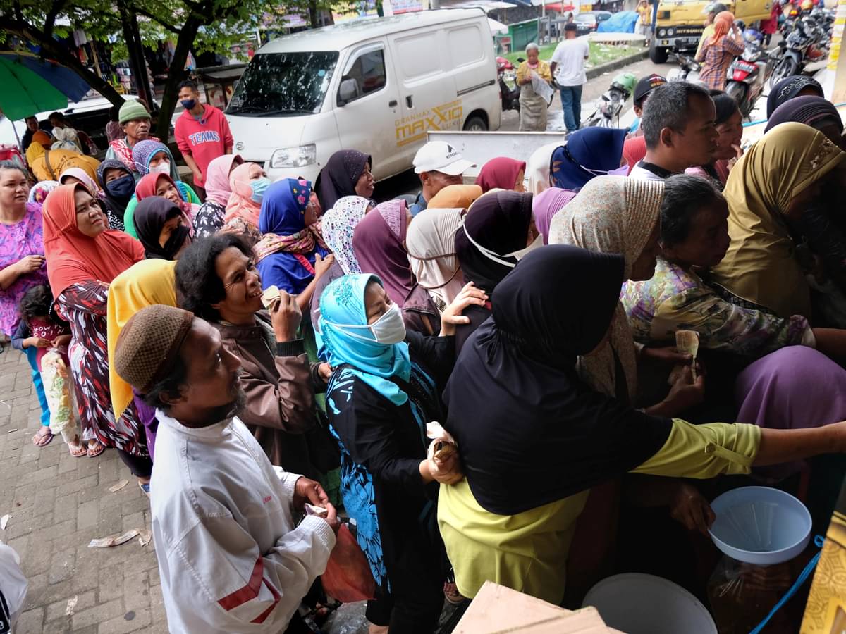 Sejumlah warga berebut membeli minyak goreng curah di sebuah toko sembako di kompleks pasar Bandongan, Magelang, Jawa Tengah, Sabtu (26/3).