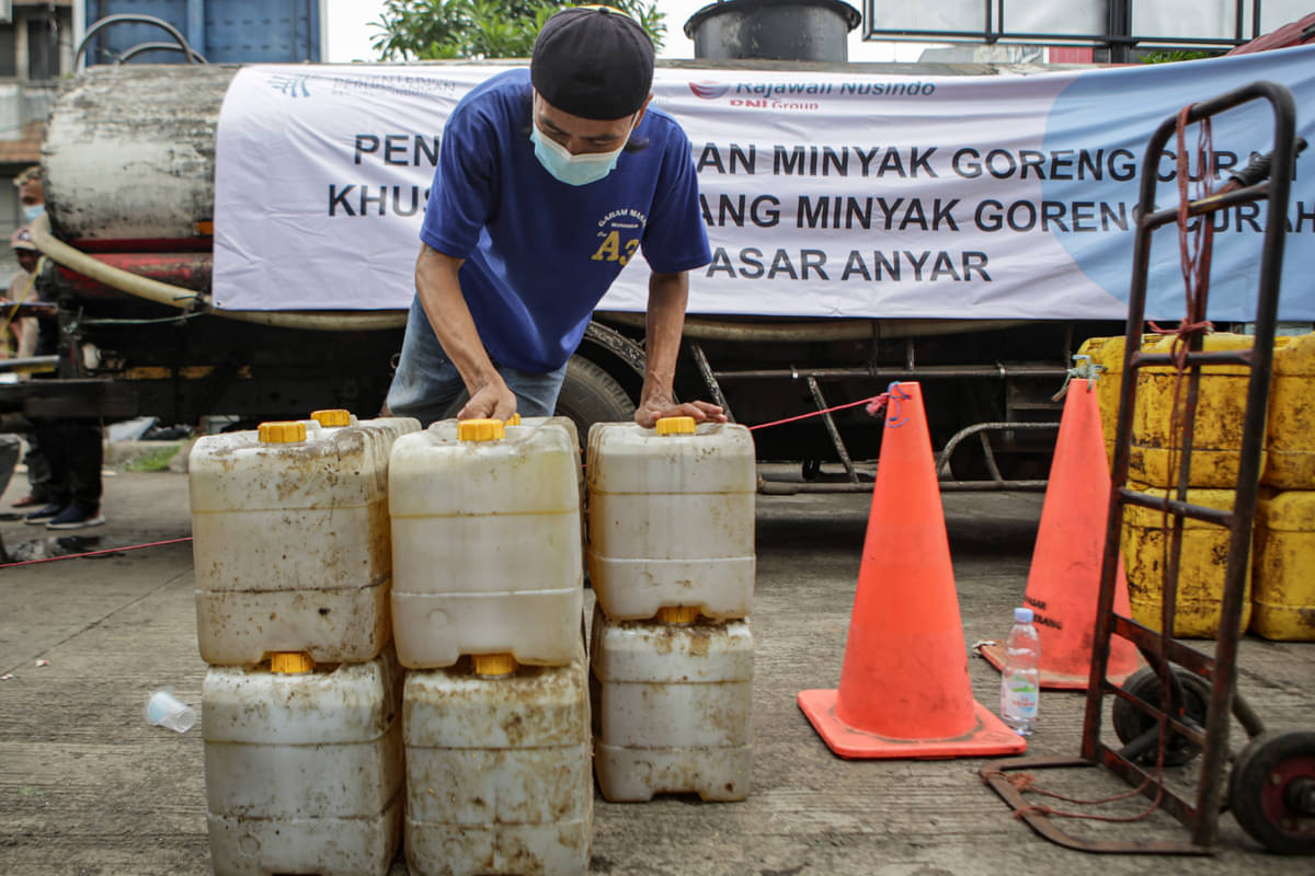 Pedagang membawa jeriken berisi minyak goreng curah saat pendistribusian di Pasar Anyar, Kota Tangerang, Banten, Selasa (29/3/2022)