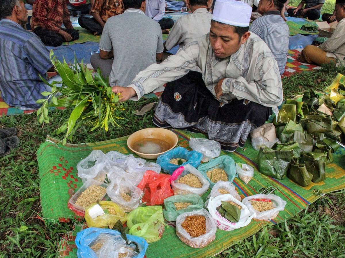 Petua adat melakukan peusijuk (teupung tawar) benih padi sebelum disemai saat kenduri blang akbar (kenduri turun kesawah), Desa Keude Krung.