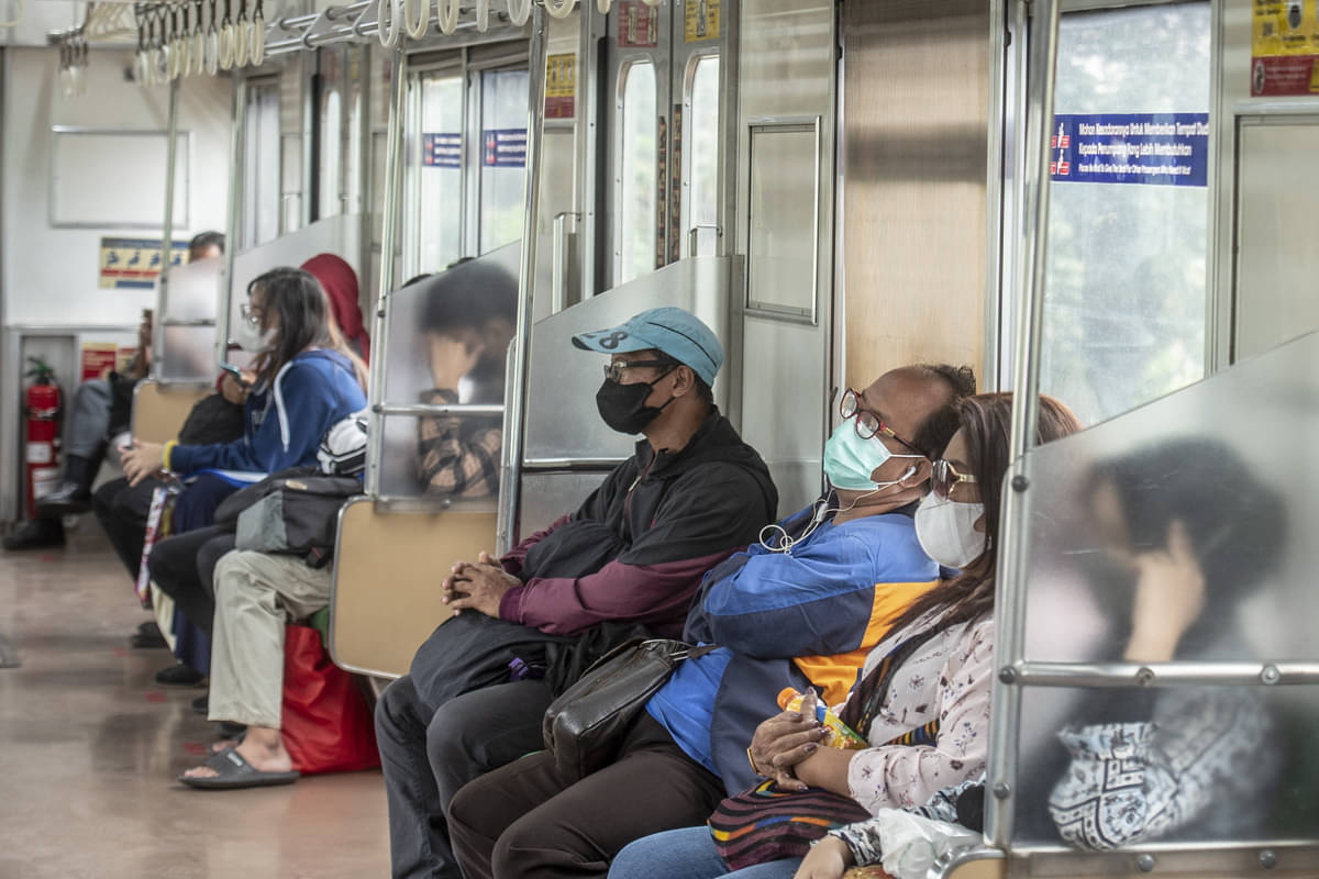 Penumpang dengan tetap menggunakan masker di dalam KRL Commuter Line, Jakarta.