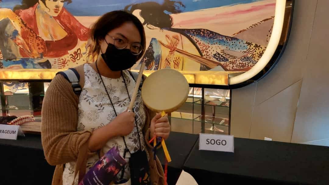 Penonton pertunjukan lagu dan tarian tradisional Korea berpose sembari memegang Sogo