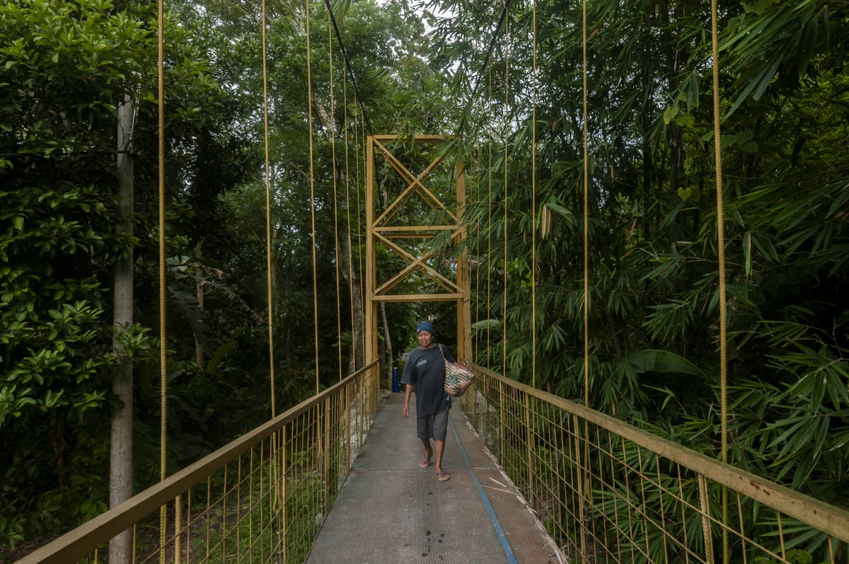 Ilustrasi: Pejalan kaki melintas di jembatan gantung yang dibangun dengan dana desa