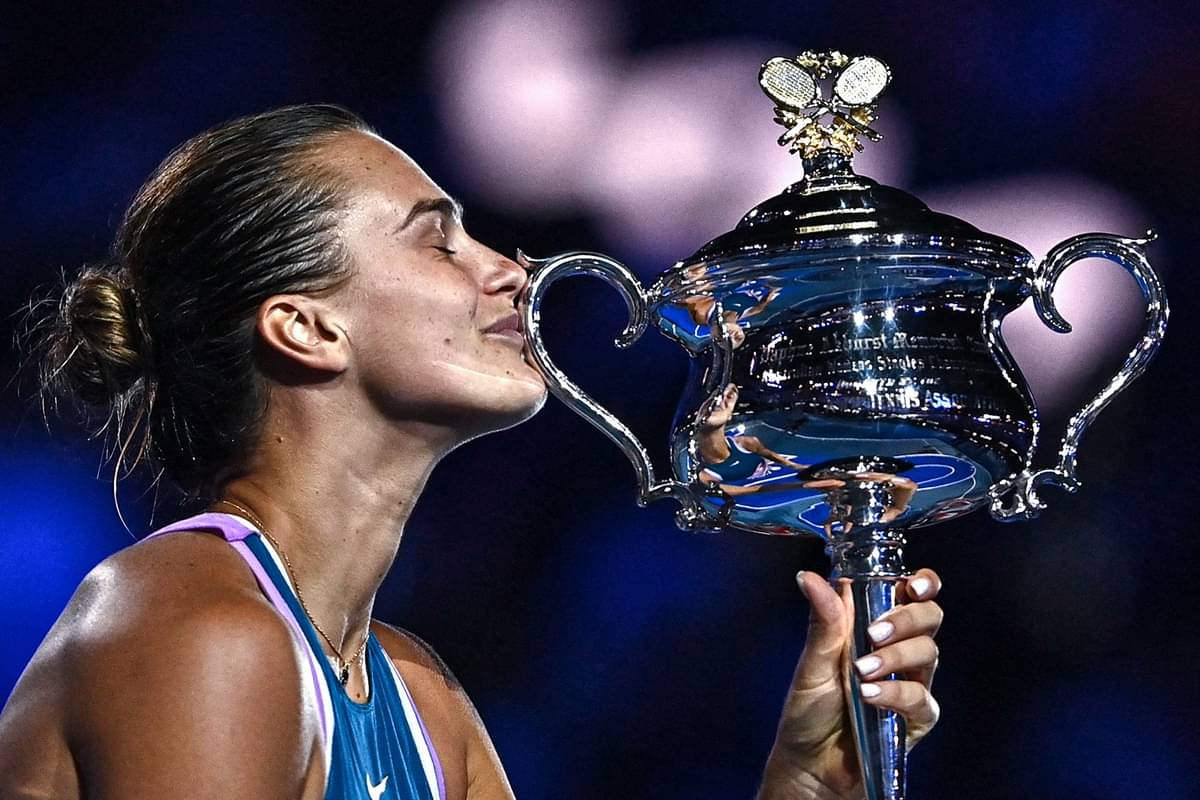 Petenis Belarus Aryna Sabalenka mencium trofi Australia Terbuka yang merupakan gelar grand slam pertamanya, Sabtu (28/1).