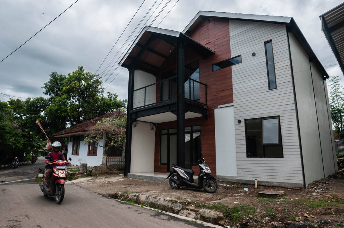 Warga melintas di depan rumah tahan gempa di Rangkasbitung, Lebak, Banten, Jumat (21/1/2022). 