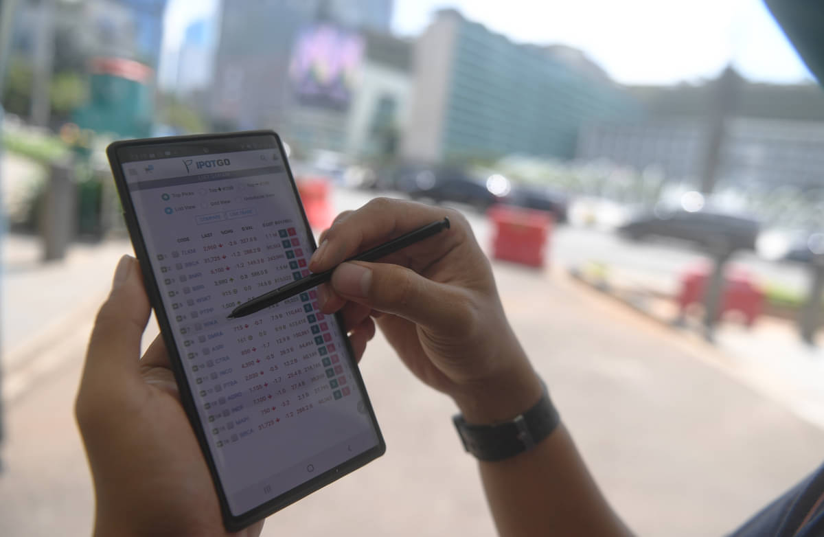 Investor memantau perdagangan saham melalui gawainya di Jakarta, Jumat (13/11/2020). 