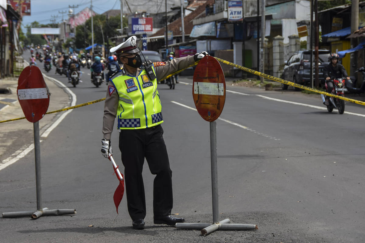 Seorang polisi tengah mengatur arus lalu lintas.