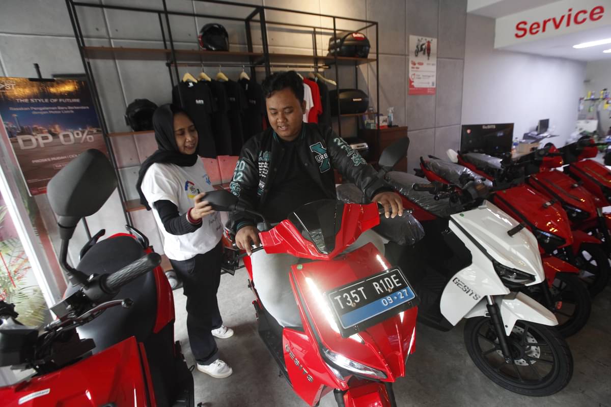 Tenaga penjual memberikan edukasi kepada calon pembeli terkait produk kendaraan listrik di diler motor listrik Gesits di kawasan Bintaro.
