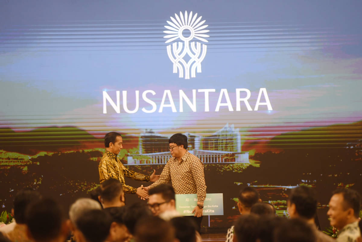 Presiden Joko Widodo (kiri) berjabat tangan dengan pemenang sayembara logo Ibu Kota Nusantara (IKN) Aulia Akbar (kanan) di Istana Negara