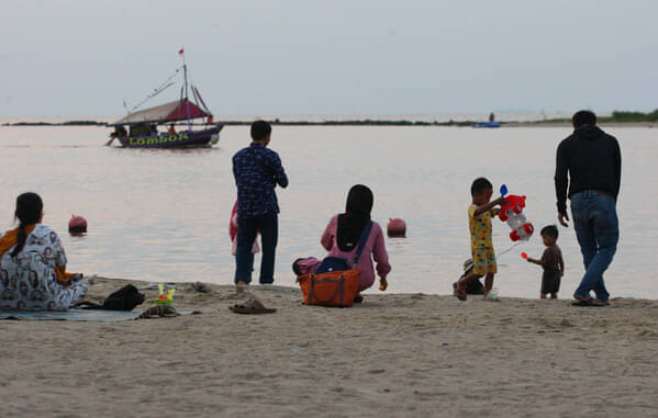 Pengunjung bermain di Pantai Lagoon, Ancol, Jakarta.