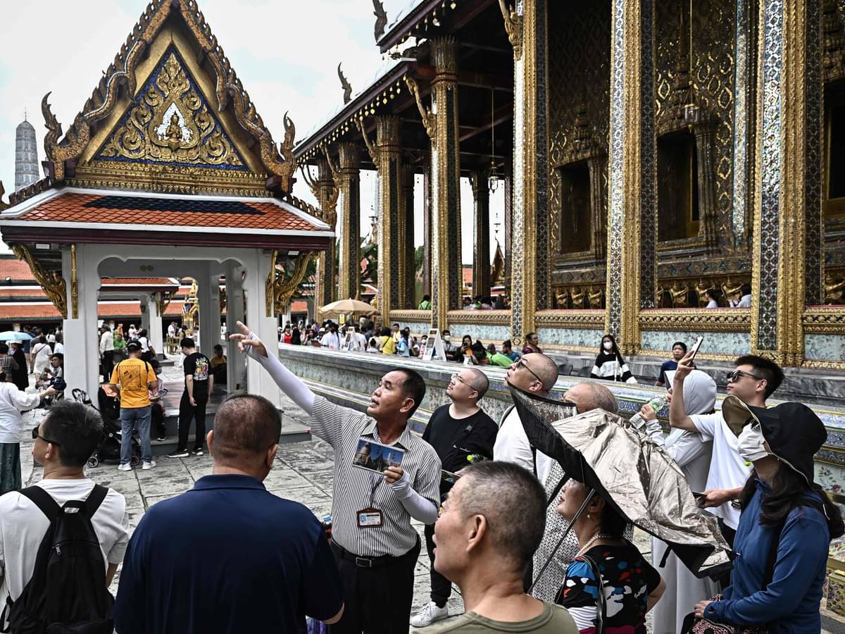 Seorang pemandu wisata Thailand (tengah) bersama sekelompok turis Tiongkok di Grand Palace Bangkok.