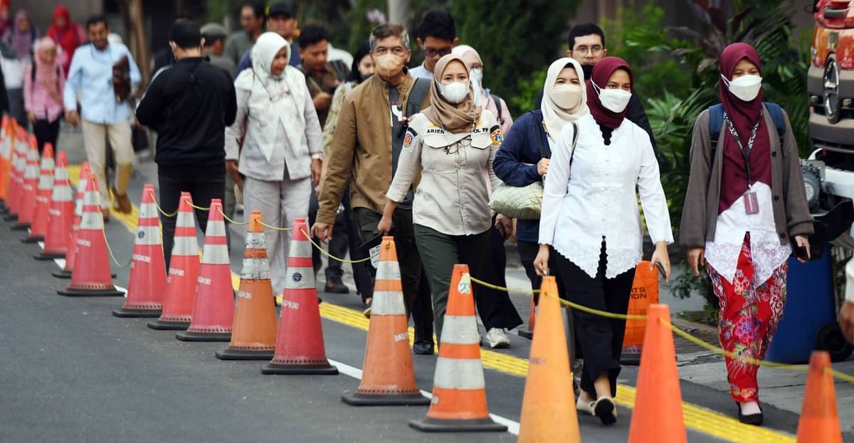 Pegawai Pemprov DKI Jakarta berjalan keluar saat jam pulang kerja di depan Balai Kota, Jakarta, Jumat (18/8/2023)