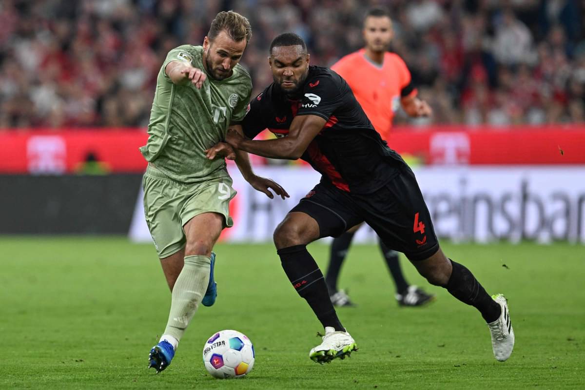 Striker Bayern Muenchen Harry Kane (kiri) dan bek Leverkusen Jonathan Tah berebut bola.