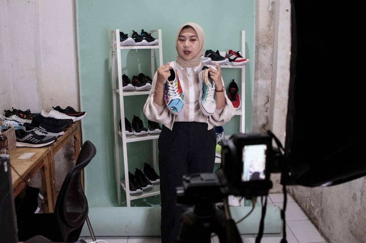 Pedangan melakukan live shopping di layanan e-commerce