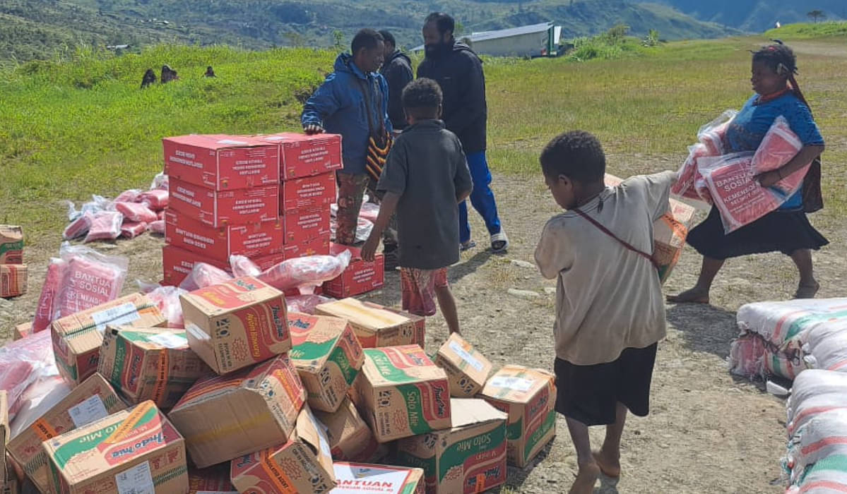 Sejumlah warga membawa bahan makanan yang diturunkan dari pesawat terbang di Distrik Amuma, Kabupaten Yahukimo, Papua Pegunungan.