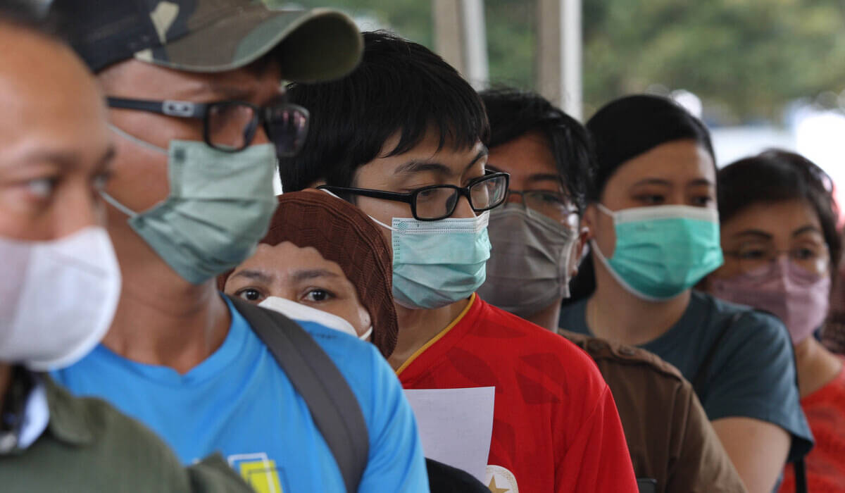 Warga menggunakan masker antre untuk mendapatkan suntikan vaksin Covid-19 booster ke-2 (dosis keempat) di Balai Kota, Jakarta.