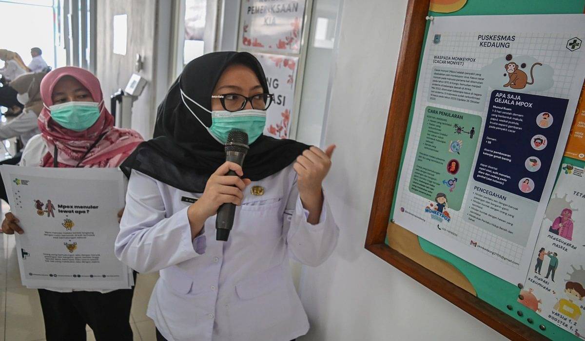Dua petugas kesehatan menyosialisasikan penyakit cacar monyet kepada masyarakat di Puskesmas Kedaung, Tangerang Selatan, Banten.