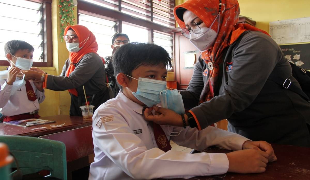 Ilustrasi--Sejumlah petugas memasangkan masker kepada murid Sekolah Dasar Negeri (SDN) 01 Alang Laweh di Padang, Sumatra Barat.