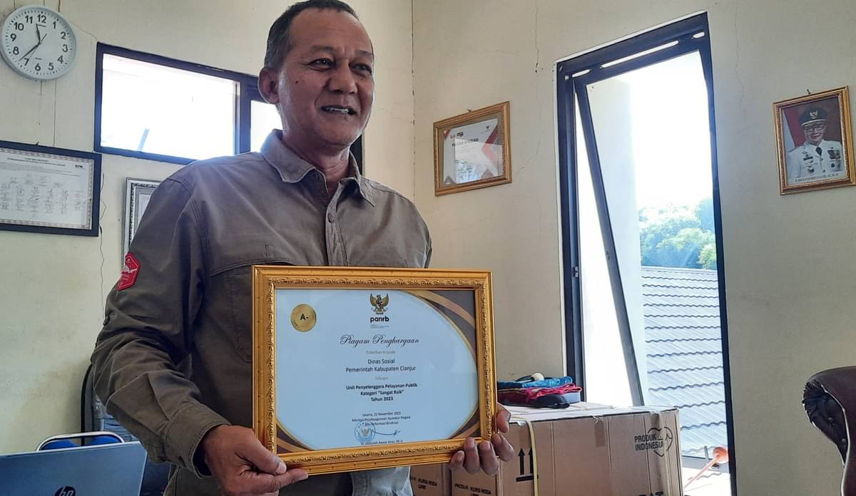 Kepala Dinas Sosial Cianjur Munajat memperlihatkan penghargaan yang diterima dari Kementerian PAN-RB