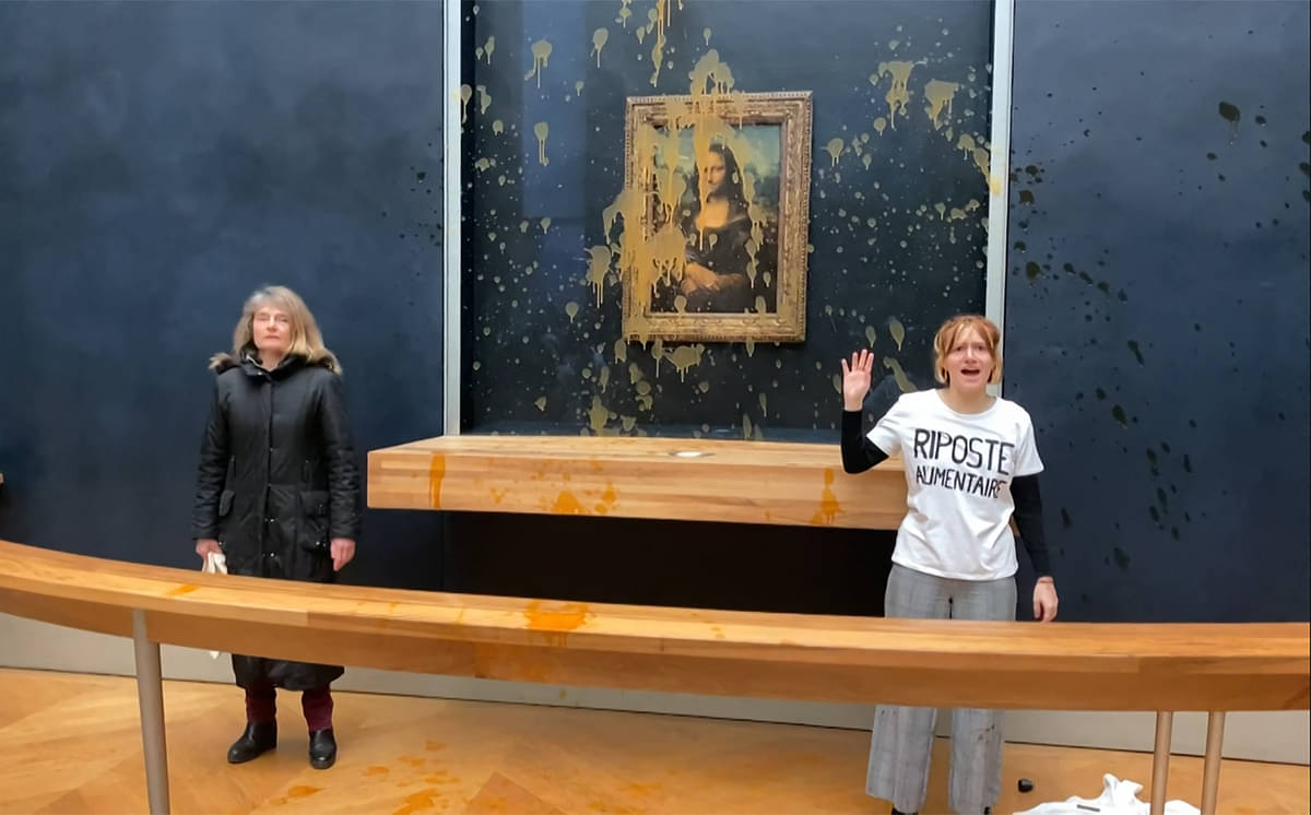 Gambar dari rekaman AFPTV ini menunjukkan dua aktivis lingkungan hidup yang menyiram sup ke lukisan Mona Lisa di Paris.