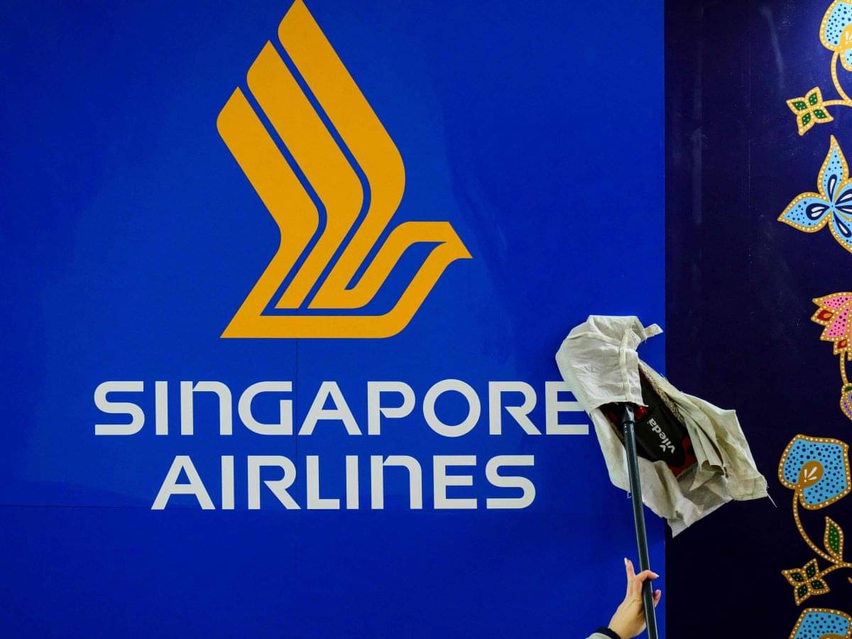 Seorang pekerja menyeka logo Singapore Airlines di Pameran Dagang Pariwisata Internasional, Berlin, Jerman, pada 6 Maret 2023.