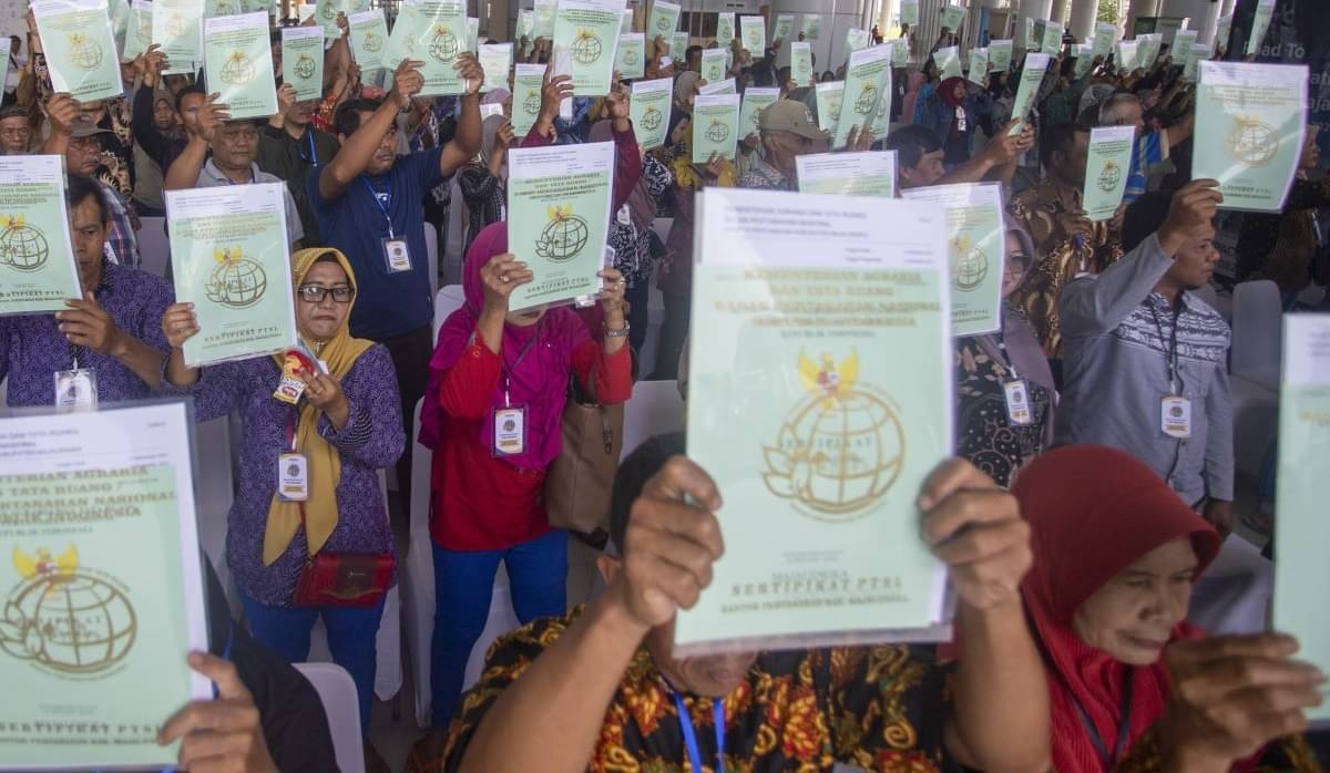 Warga menunjukkan sertifikat yang baru diterima pada penyerahan sertifikat PTSL di Bandara Kertajati, Majalengka, Jabar, Jumat (26/1/2024).