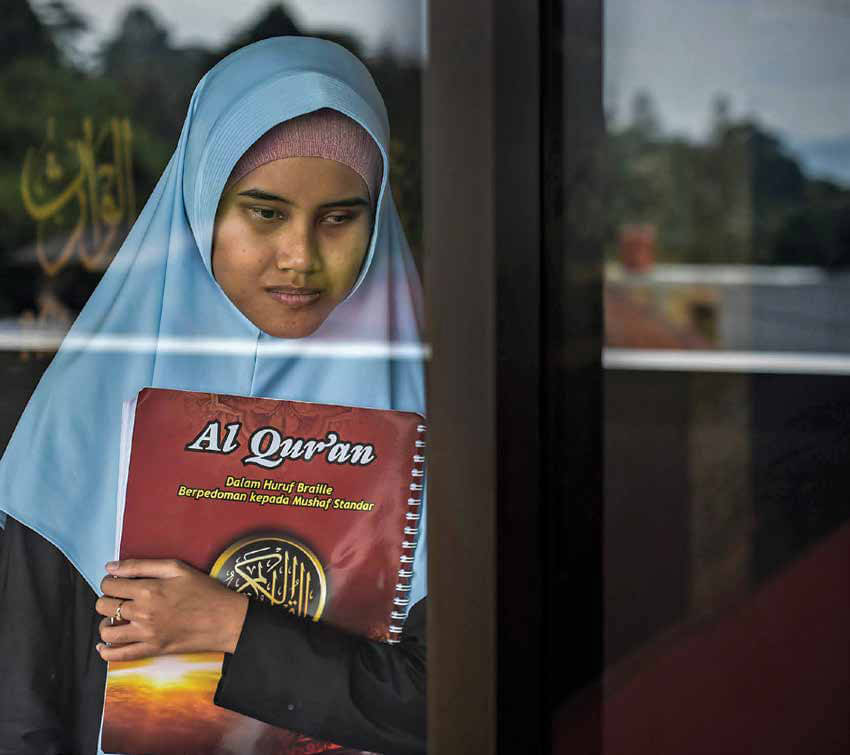 Zarfa (19) memegangi Al-Qur’an Braille di Masjid Pesantren Tunanetra Sam’an Darushudur. MI/Bilal Nugraha Ginanjar