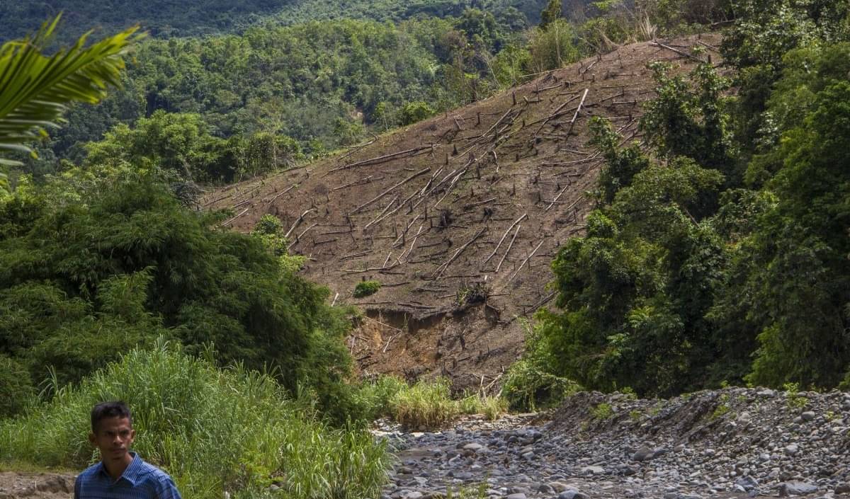 Seorang warga berjalan di permukiman penduduk di kaki Pegunungan Meratus, Desa Datar Ajab, Kabupaten Hulu Sungai Tengah, Kalimantan Selatan.