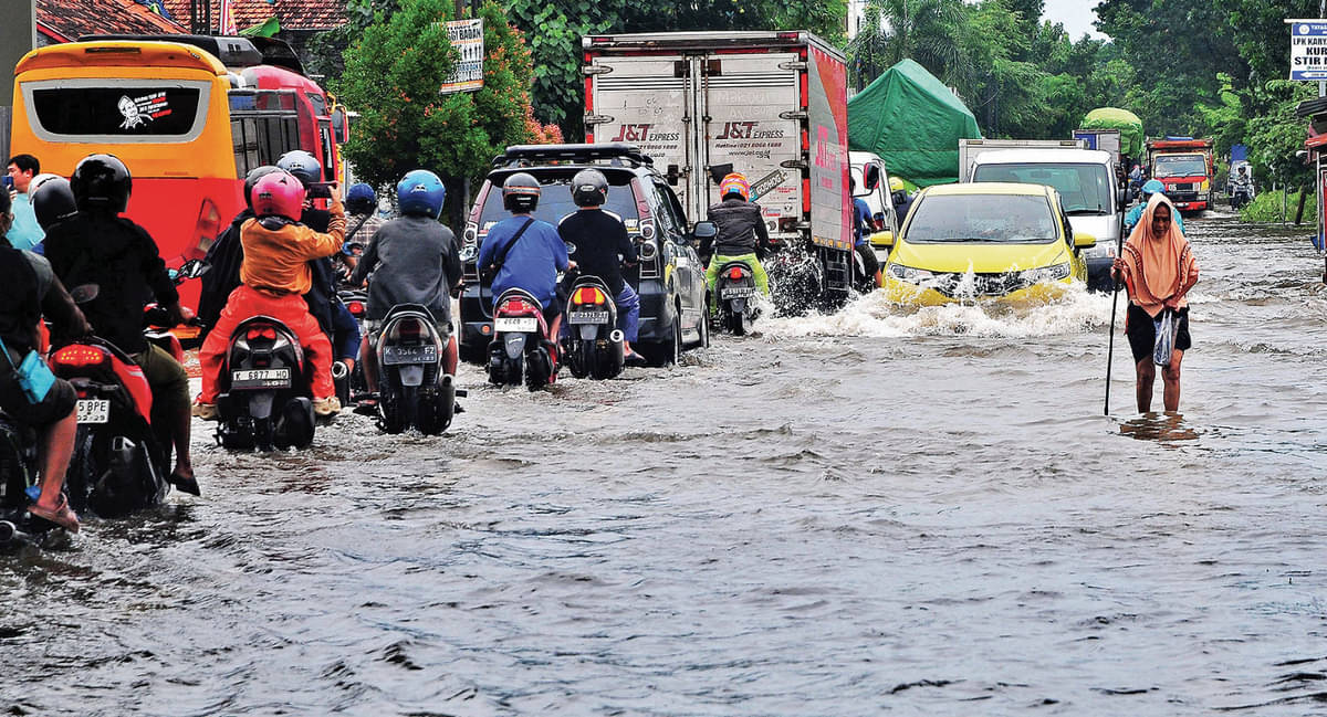 Sejumlah pengendara melintasi jalan yang tergenang oleh banjir di Desa Tanjung Karang, Jati, Kudus, Jawa Tengah, kemarin.