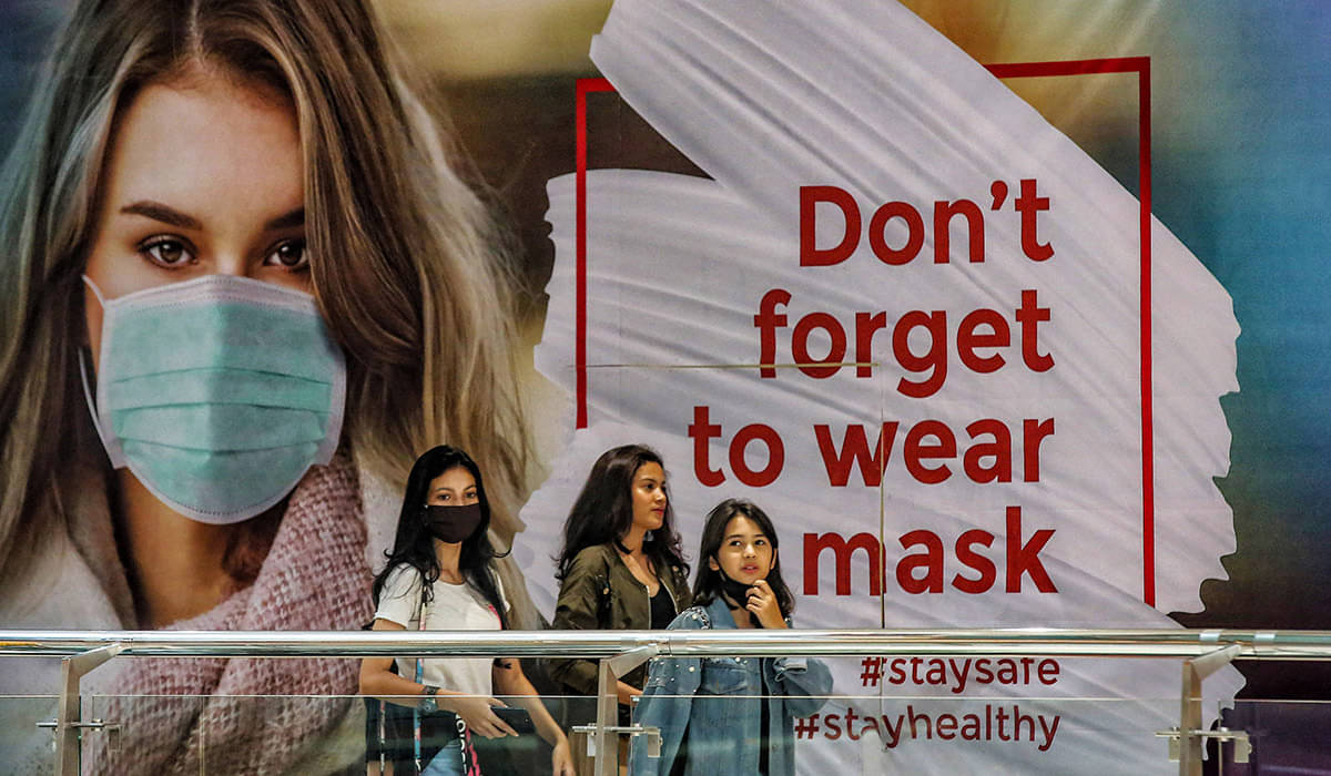 Pengunjung melewati imbauan mengenakan masker saat mengunjungi pusat perbelanjaan di Jakarta.