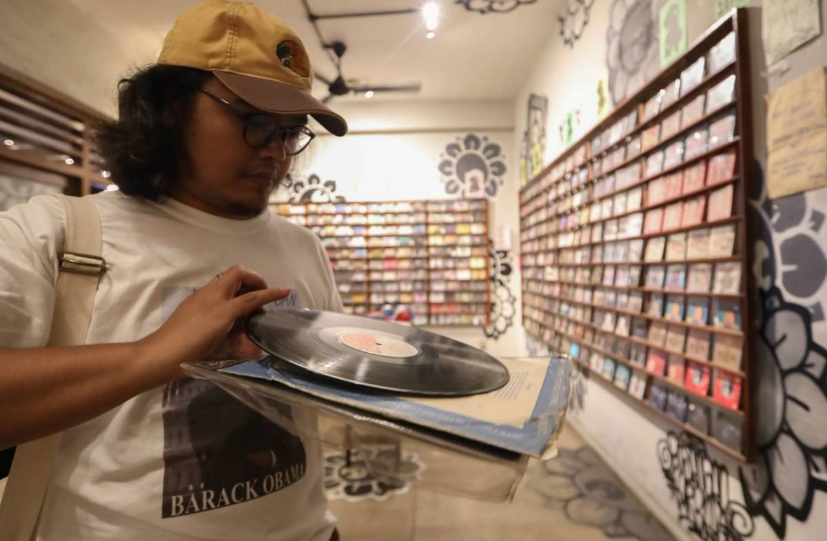 Pengunjung memeriksa kondisi piringan hitam saat berburu di Toko Demajors M Bloc, Blok M, Jakarta Selatan, Kamis (7/3).