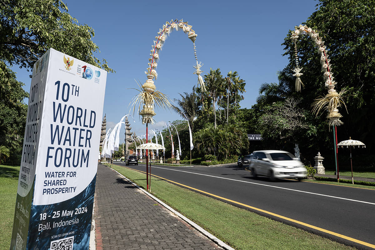 Kendaraan melintas di jalan yang pinggirnya dihiasi baliho World Water Forum ke-10 dan penjor di jalan Ngurah Rai, Nusa Dua, Bali.
