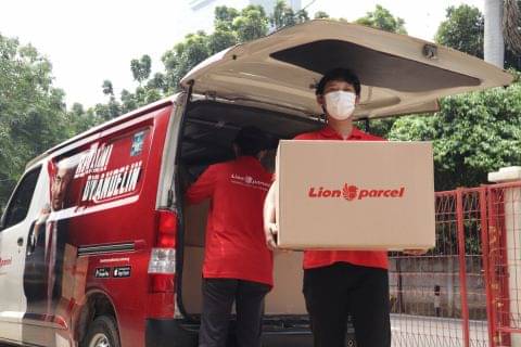Petugas Lion Parcel mengantarkan paket kepada konsumen.