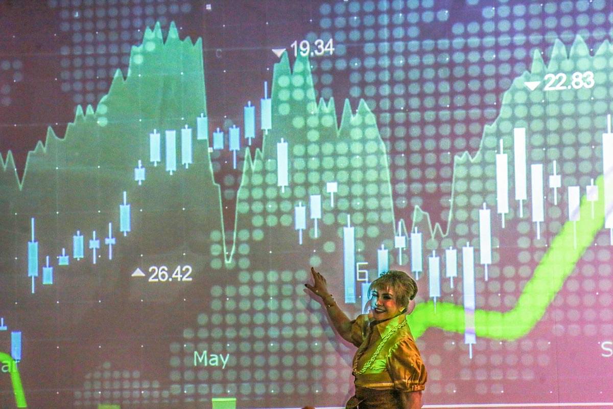 Pengunjung berfoto dengan latar belakang layar yang menampilkan pergerakan Indeks Harga Saham Gabungan (IHSG) di BEI, Jakarta.