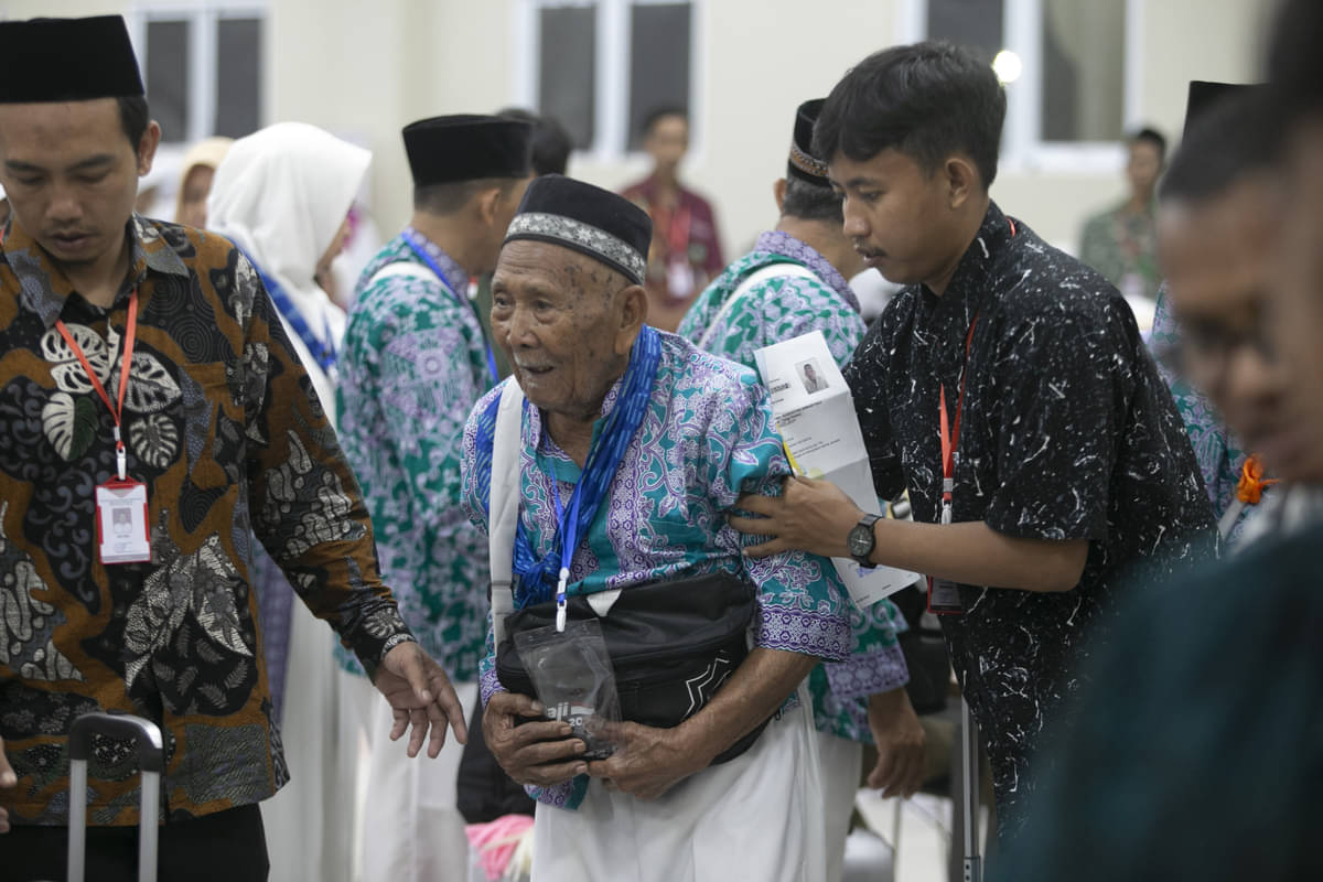Petugas membantu seorang calon jemaah haji di Majalengka