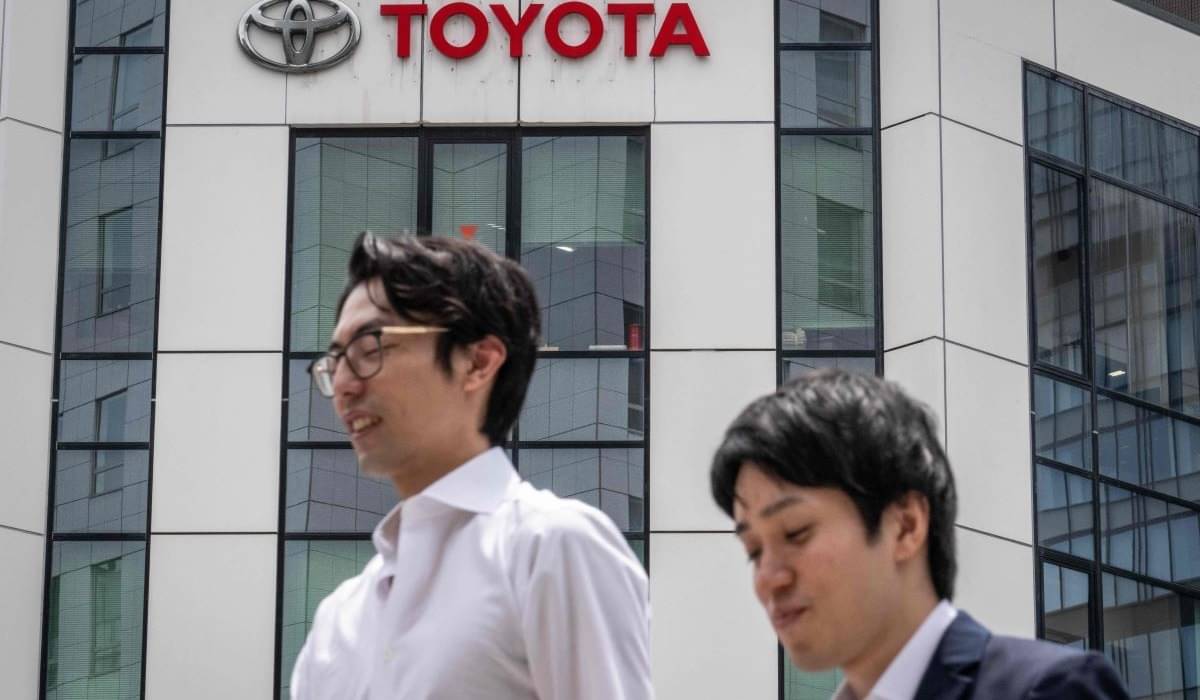 Pejalan kaki melewati dealer mobil produsen mobil Jepang Toyota di Tokyo pada 8 Mei 2024.