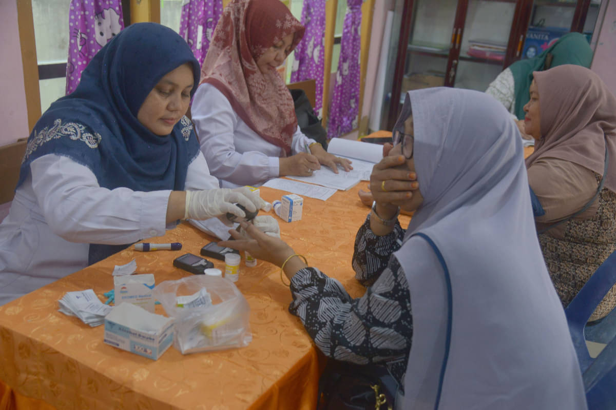 Petugas Puskesmas mengambil sampel darah lansia saat pemeriksaan kesehatan di Pos Pelayanan Terpadu (Posyandu)