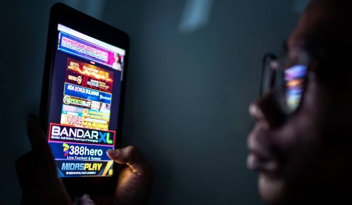 Warga melihat iklan judi online melalui gawainya di Jakarta, Rabu (19/6/2024).