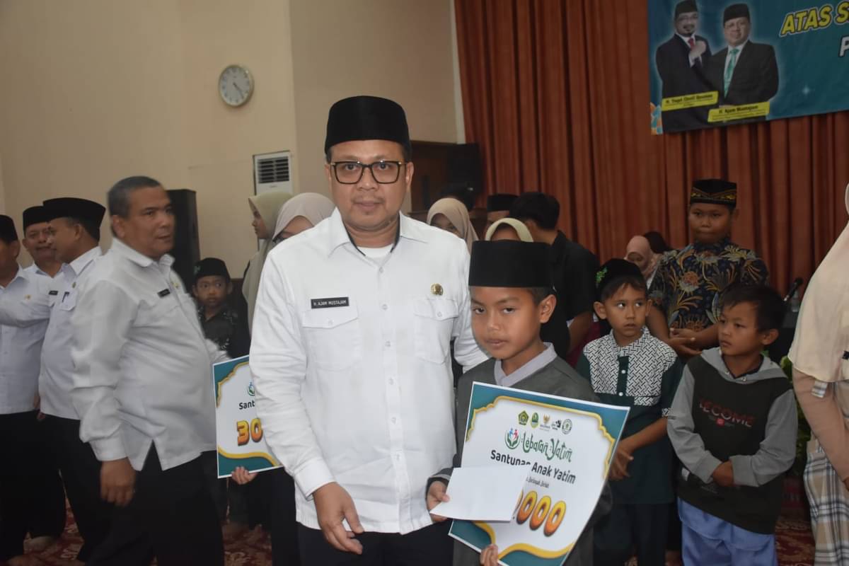  Kepala Kanwil Kemenag Jabar H Ajam Mustajam menyerahkan santunan pada anak yatim dalam acara  tasyakur bin nimah. 