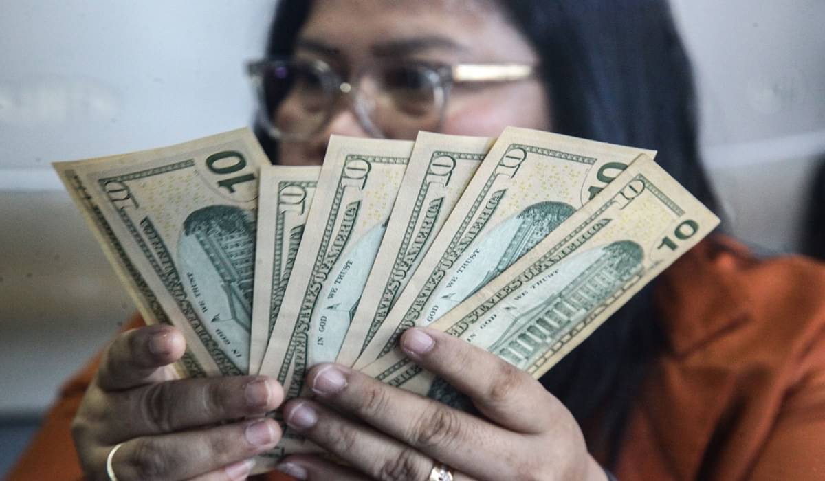 Petugas menghitung uang pecahan dolar AS dan rupiah di gerai jasa penukaran mata uang asing, ,Menteng, Jakarta Pusat.