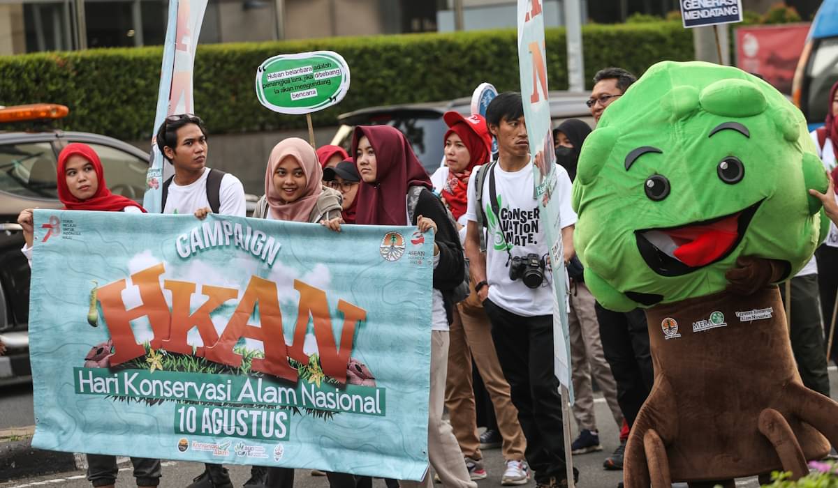 Sejumlah relawan membawa spanduk kampanye Hari Konservasi Alam Nasional 