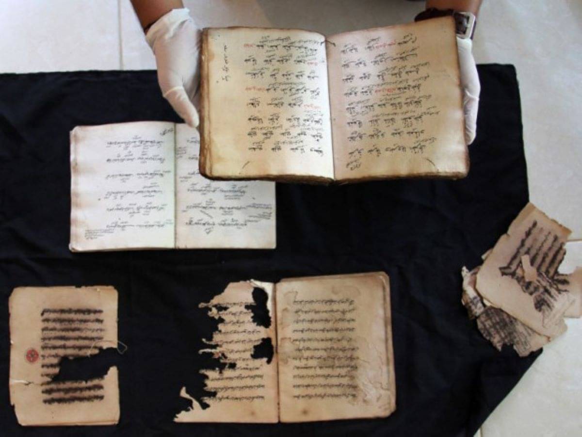 Petugas memperlihatkan kitab yang rusak dan yang masih utuh saat proses digitalisasi manuskrip di Padang, Sumatera Bara