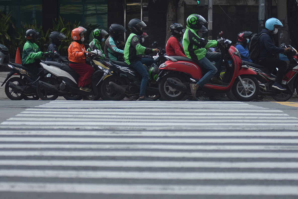 Pengemudi ojek online melintas di kawasan Mampang Prapatan, Jakarta, Jumat (9/9/2022).